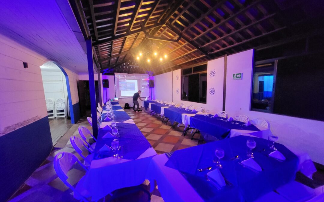 Evento corporativo con mesas imperiales y proyector
